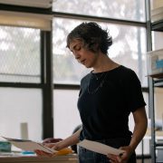 Lisa DiClerico looking at watercolors she painted during quarantine: “A lot of work done during that time felt meditative and almost like a ritual. Maybe it was me finding a way back into calm, or maybe just undoing the day.” | José A. Alvarado Jr. for The Daring