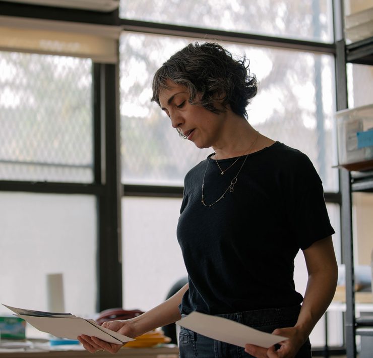 Lisa DiClerico looking at watercolors she painted during quarantine: “A lot of work done during that time felt meditative and almost like a ritual. Maybe it was me finding a way back into calm, or maybe just undoing the day.” | José A. Alvarado Jr. for The Daring